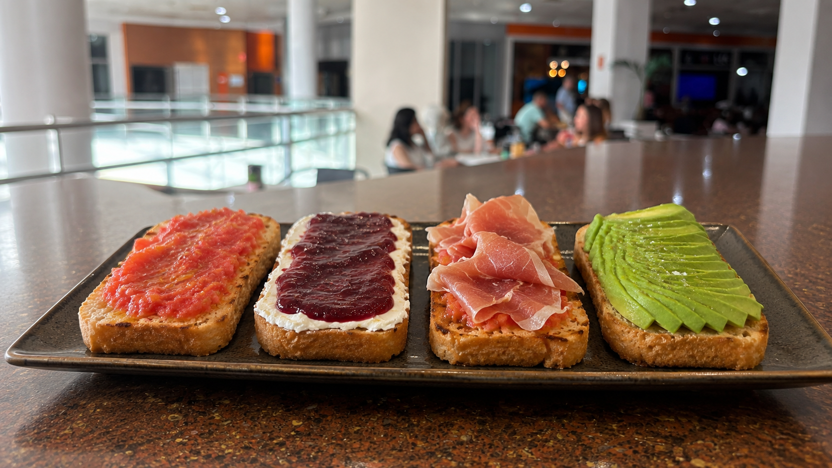 Tostadas de tomate, queso crema con mermelada, jamón serrano y aguacate